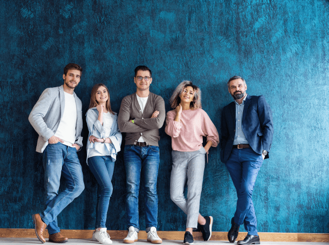 The InfluencerDB.net editorial team standing together in front of a blue wall, smiling and relaxed.