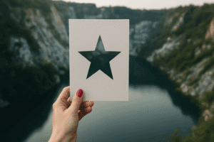 Hand holding a postcard with a cut‑out star against a rugged canyon – symbolising top‑tier influencer campaigns. Influencer marketing campaigns 2017 visual star