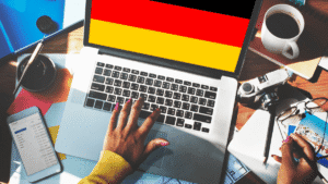 German startup workspace – laptop with German flag on screen, phone and coffee cup
