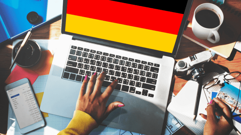 German startup workspace – laptop with German flag on screen, phone and coffee cup